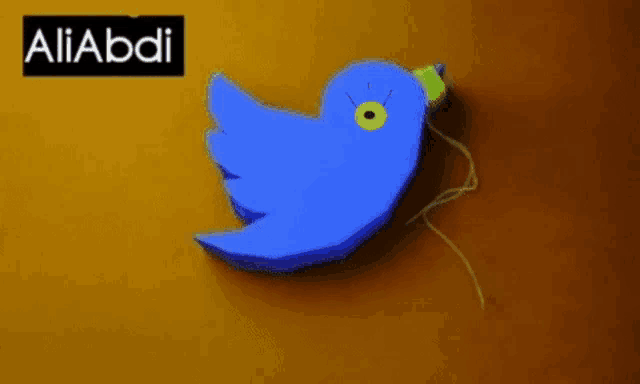 a blue bird with a yellow beak is on a yellow background with the name aliabdi