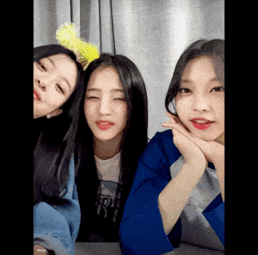 three girls are posing for a picture with one wearing a yellow flower headband