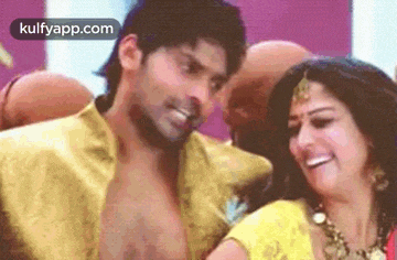 a man and a woman are dancing together in a room and smiling .
