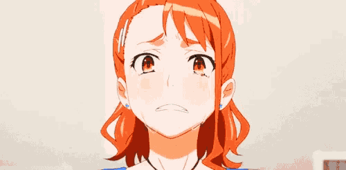 a girl with orange hair covering her face with her hand