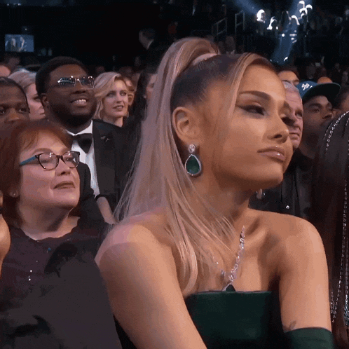 a woman in a green dress is sitting in the audience