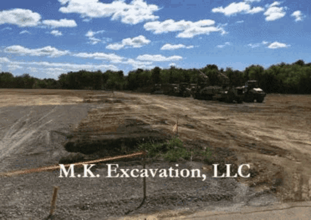 a sign for m.k. excavation llc is displayed on a dirt field