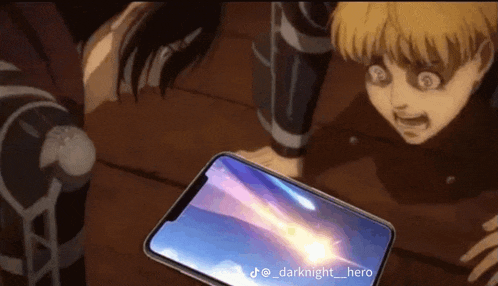 a man is holding a cell phone in front of a girl who is looking at it .
