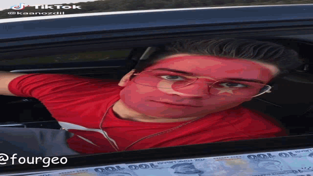 a man with his face painted red is in a car