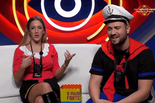 a man and a woman are sitting on a couch with a box that says o mais forte