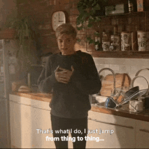 a man is standing in a kitchen with a clock on the wall behind him and says that 's what i do
