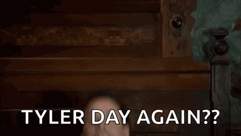 a man is laying on a bed with the words `` tyler day again '' written on the screen .