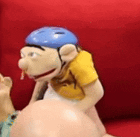 a puppet wearing a blue helmet is sitting on a couch .