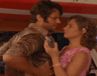 a shirtless man is kissing a woman on the forehead .