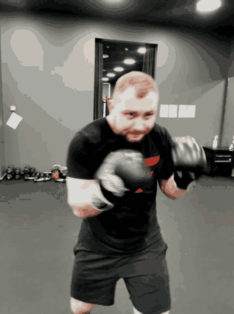 a man wearing boxing gloves and a black shirt that says ' a ' on it