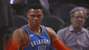 a basketball player with oklahoma city on his shirt