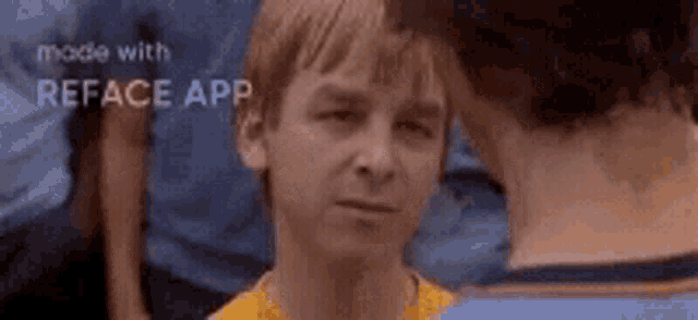 two boys are looking at each other and one of them is wearing a yellow shirt .