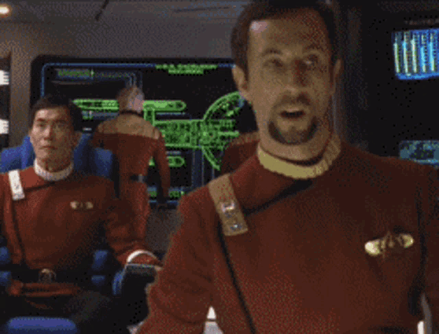 a man in a red uniform says she 'll fly apart in front of two other men