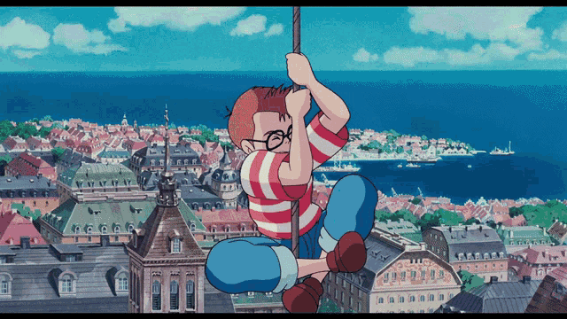 a boy in a striped shirt is hanging on a rope over a city