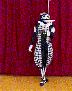a man in a black and white costume is holding a plate and a stick