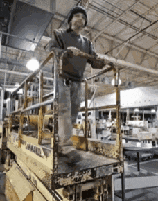 a man is standing on a lift that says ' aerial ' on it