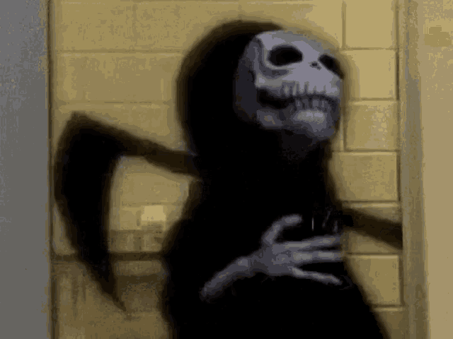 a grim reaper with a scythe is standing in front of a yellow tiled wall .