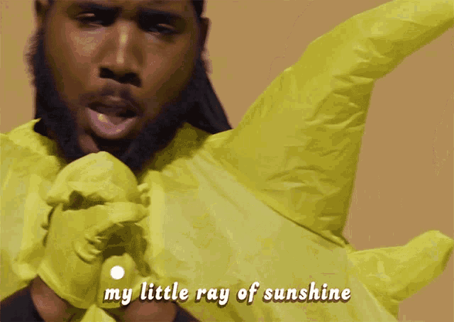 a man wearing yellow gloves is singing my little ray of sunshine