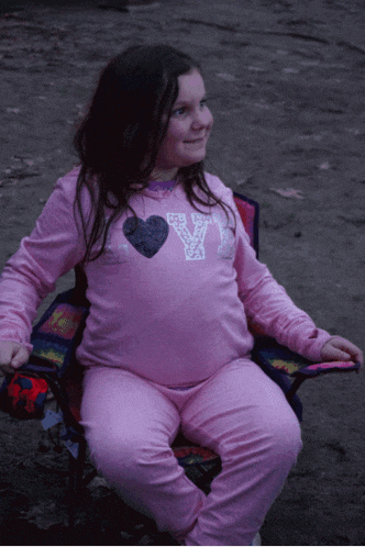 a little girl wearing a pink shirt with the letter y on it
