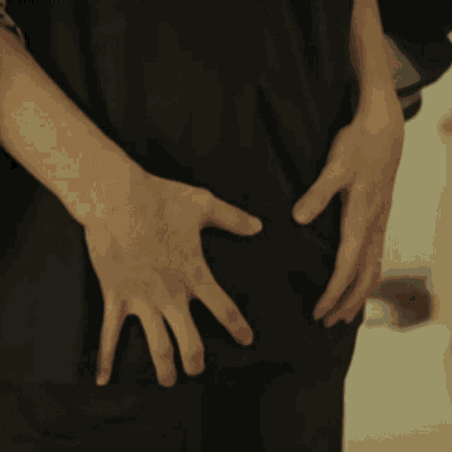 a person 's hands are on the back of another person 's butt