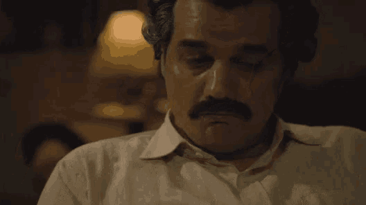 a man with a mustache says " alright " in yellow letters