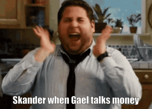 a man in a blue shirt and tie is screaming with the words skander when gael talks money written on his face
