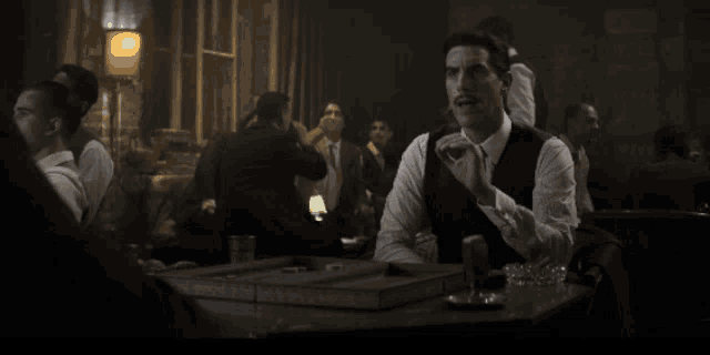 a man with a mustache is sitting at a table in a restaurant
