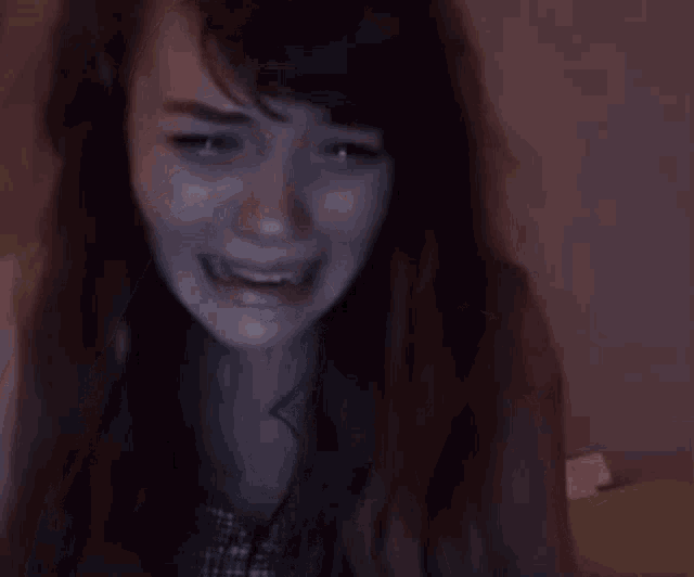 a woman is covering her face with her hands and crying