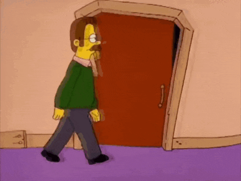 a man in a green sweater is walking through a door .