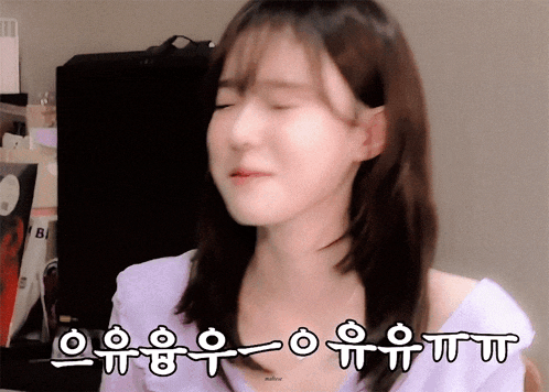 a woman in a purple shirt is making a funny face with korean writing behind her