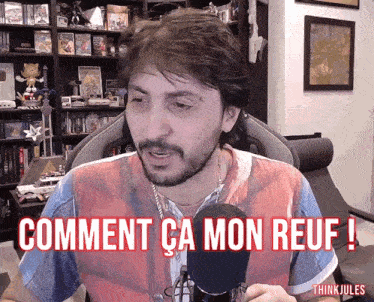 a man sitting in front of a microphone with the words comment ca mon reuf