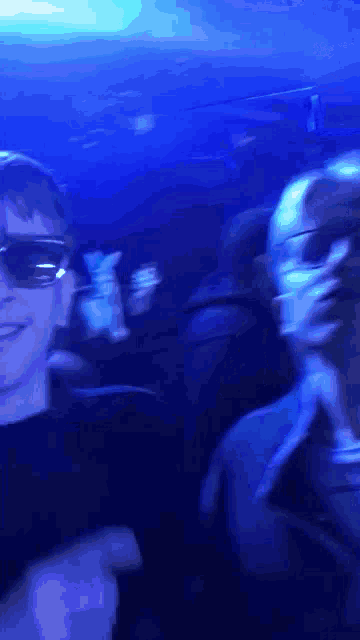 a man wearing sunglasses is standing next to another man