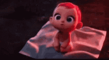 a baby with red hair is sitting on a blanket on a bed .