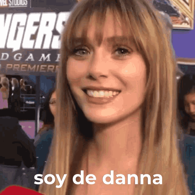 a woman stands in front of a sign that says avengers