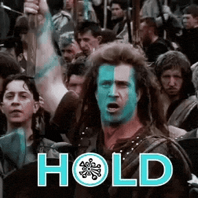 a man with blue paint on his face is holding a sword in front of a crowd of people and the word hold is above him