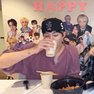 a man wearing a hat with the letter s on it is drinking from a cup