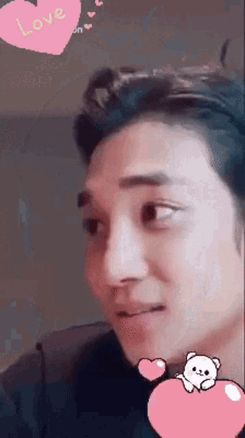 a close up of a man 's face with a pink heart with the word love on it