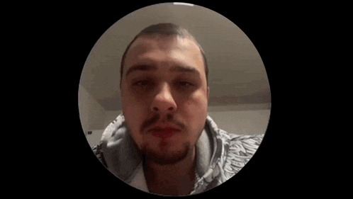 a man with a beard is in a circle and looking at the camera
