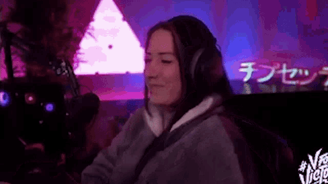 a woman wearing headphones is sitting in front of a microphone in a studio .