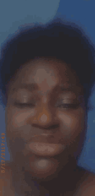 a close up of a person 's face with their eyes closed and a blue background .