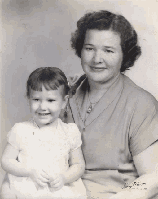 a black and white photo of a woman holding a little girl is signed by jerry anderson