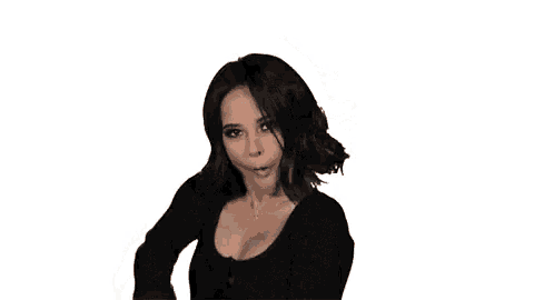 a woman in a black top is dancing with her hair in the air .