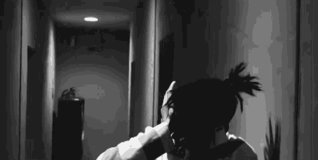 a black and white photo of a man in a hallway