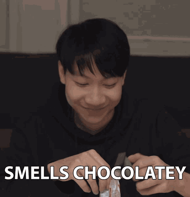 a man is smiling with the words smells chocolatey written below him