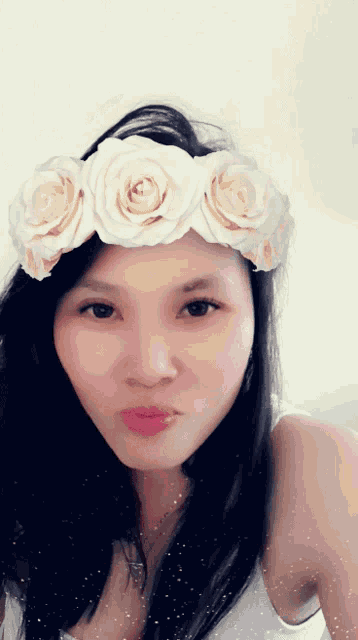 a woman wearing a flower crown on her head looks at the camera