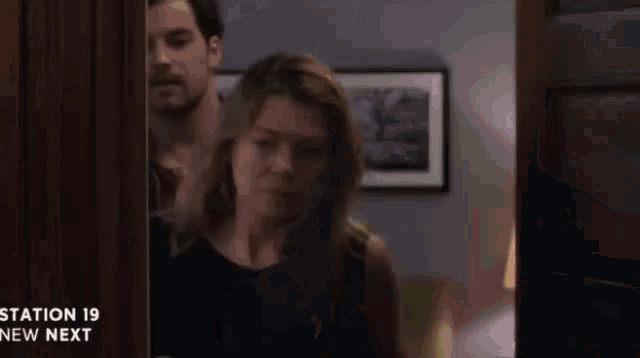 a man and a woman are standing in a doorway with the words station 19 new next on the bottom right