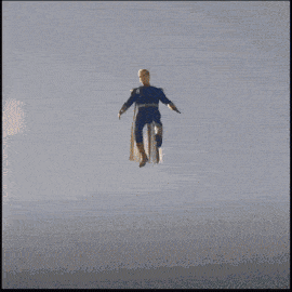 a man in a superhero costume is jumping over a wall