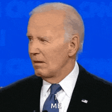 a man in a suit and tie is talking into a microphone and asking a question .