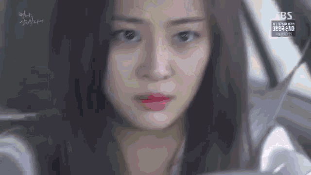 a close up of a woman 's face sitting in a car .