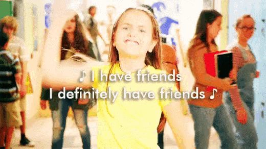 a girl in a yellow shirt is dancing in a hallway with the words i have friends i definitely have friends behind her .